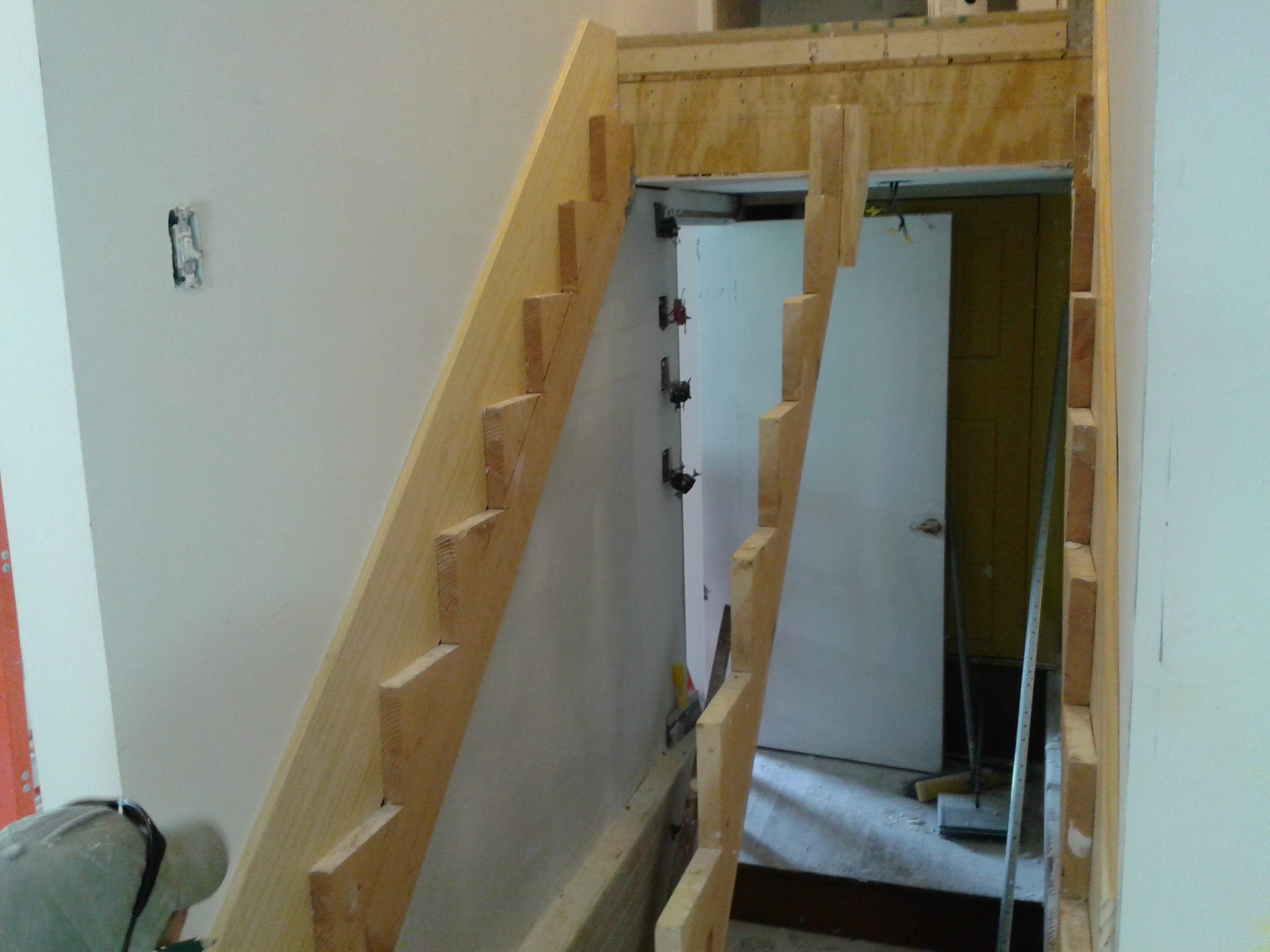 New stair stringers cut and installed with drywall complete on walls