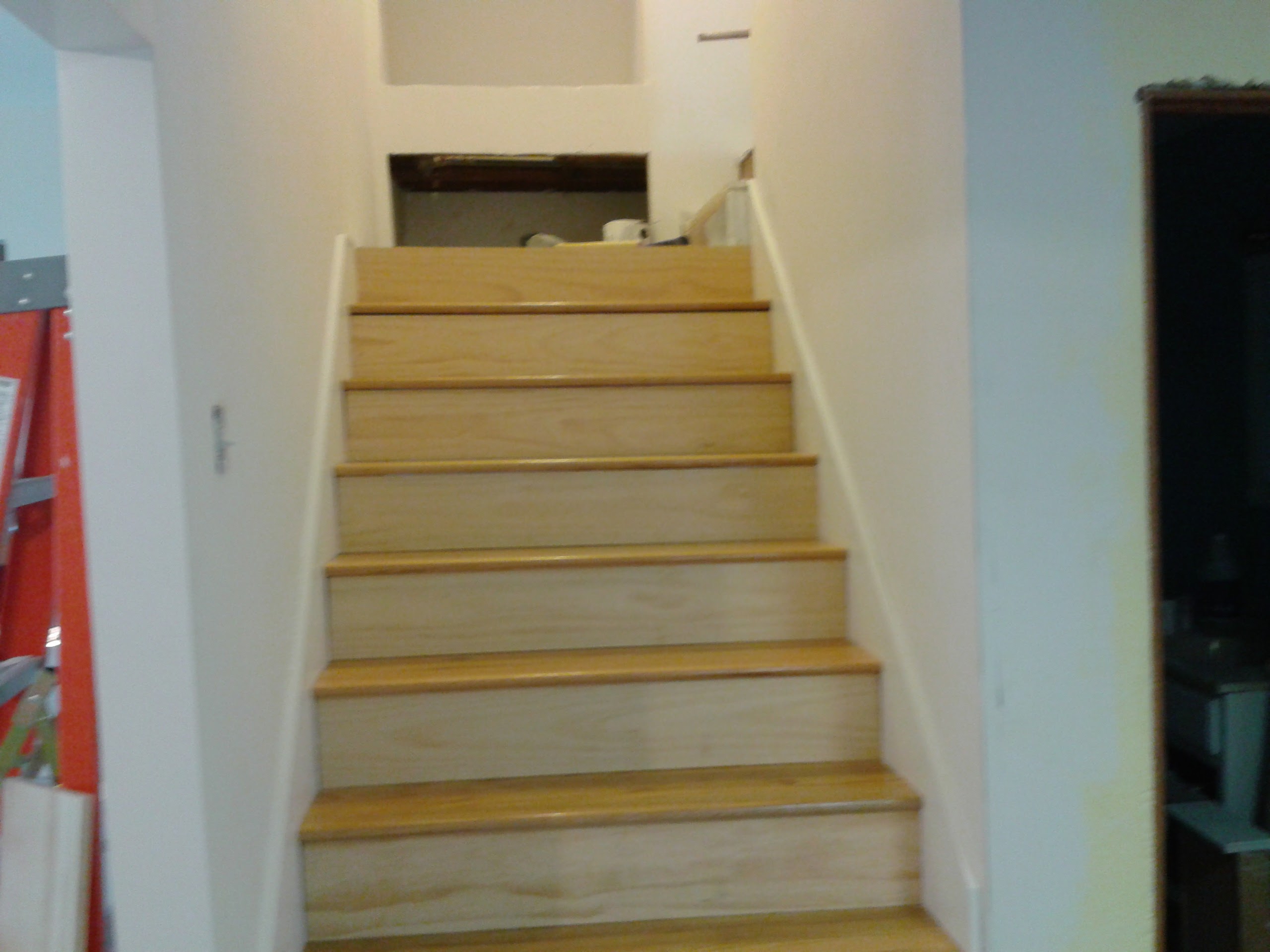 New hardwood oak treads installed on staircase with white painted risers