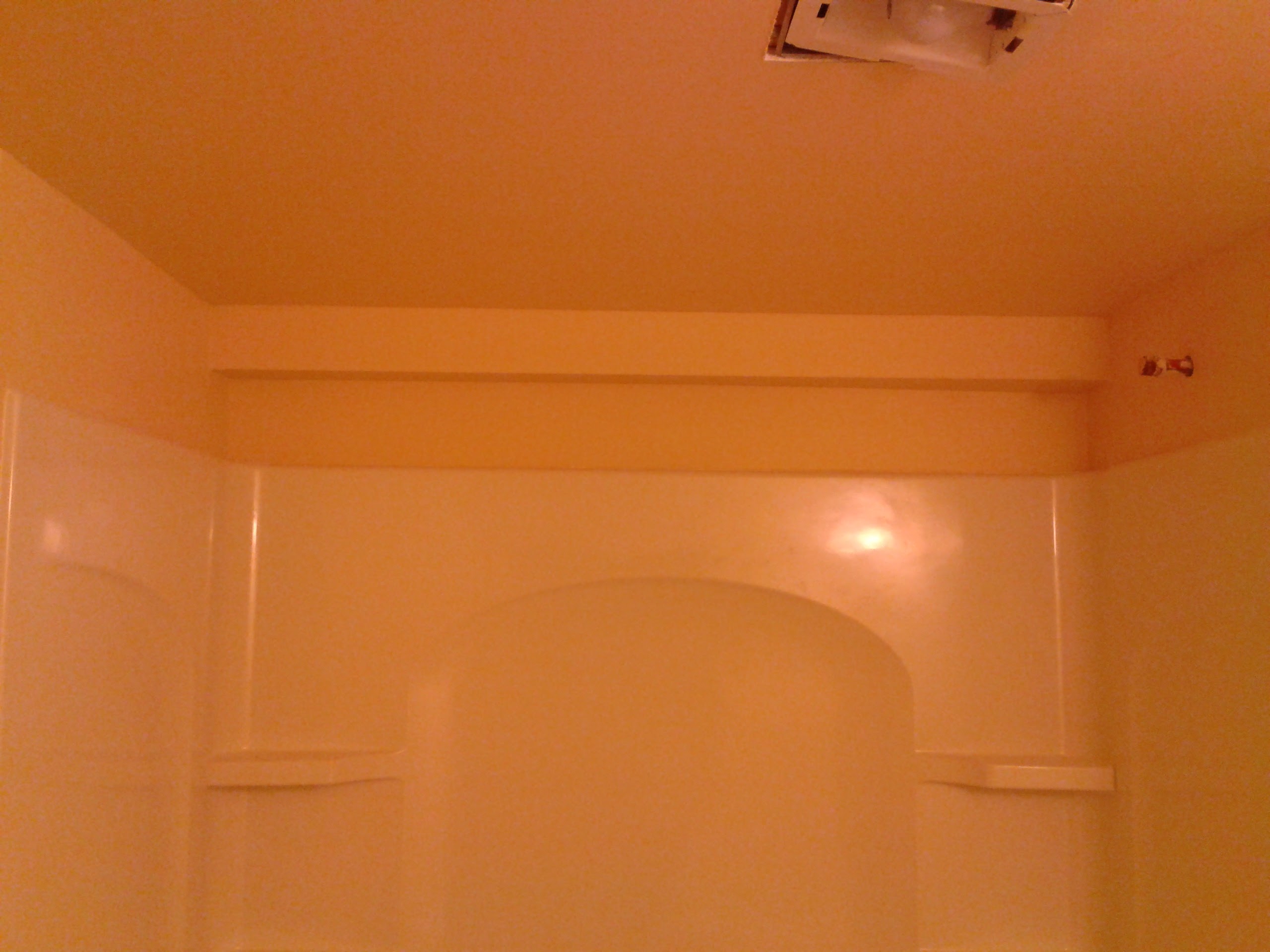 Tub surround installed with drywall nearing completion