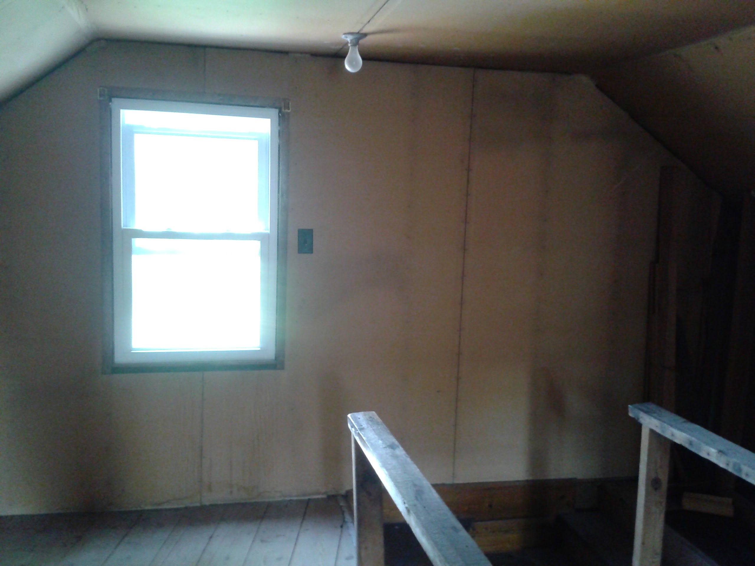 Unfinished attic space before remodel — original walls and staircase