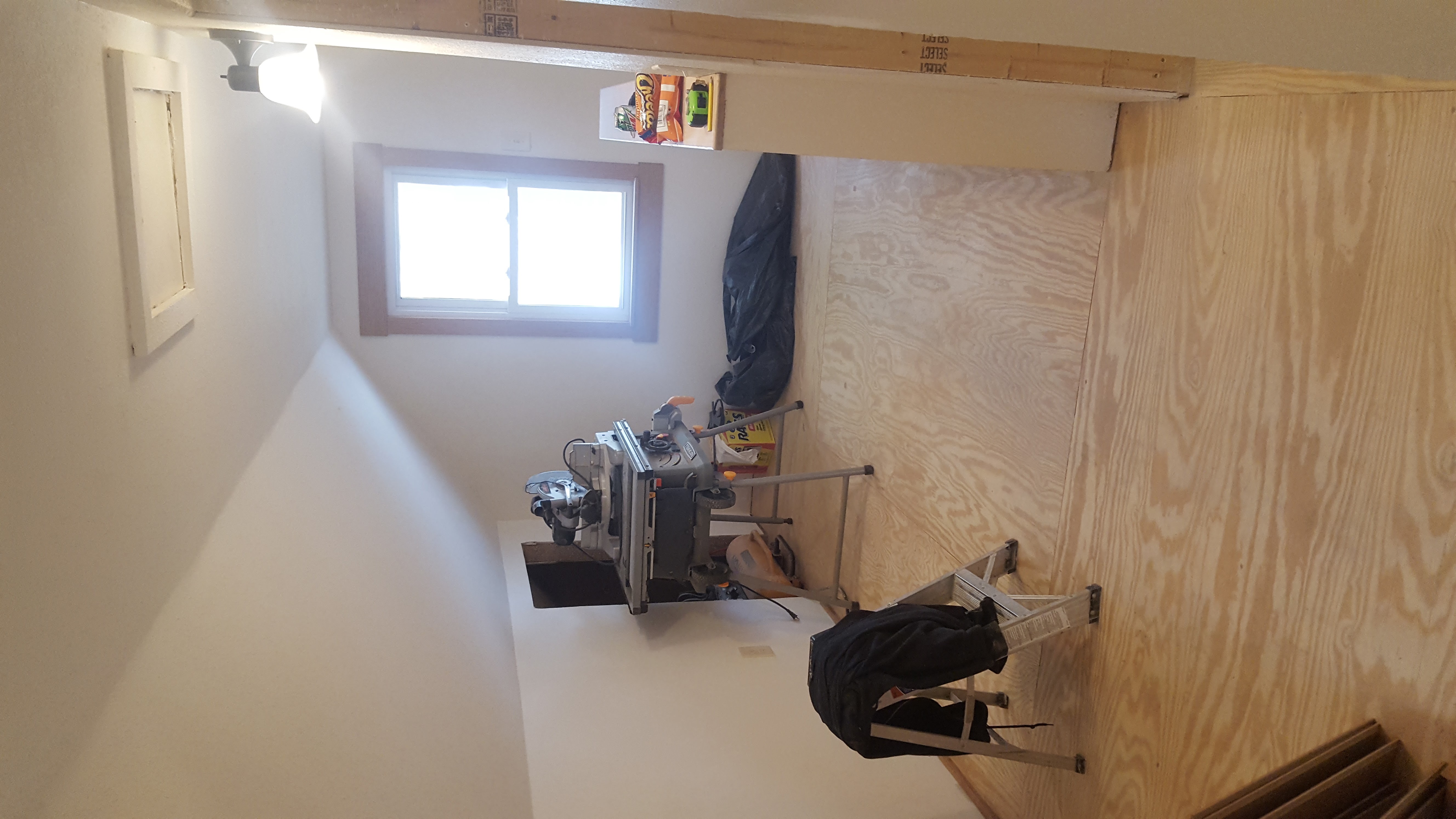 Interior framing with plywood walls and window in upper floor room