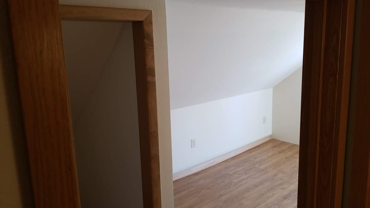 Finished bedroom with hardwood floors and clean white walls
