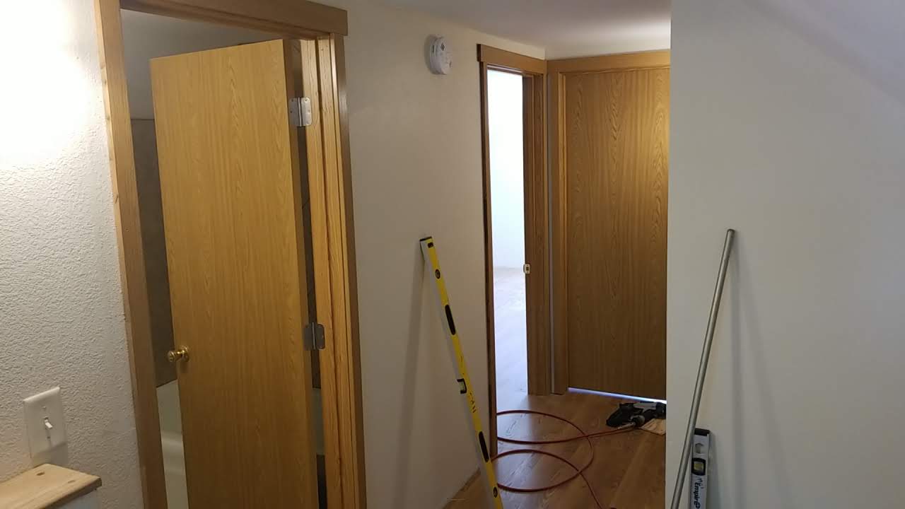Completed hallway with oak doors, trim, and hardwood flooring